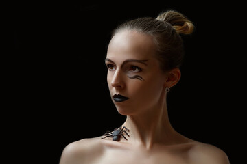 Beautiful fashion model woman with spider and black make up isolated on black. Black lipstick. Halloween cocept.