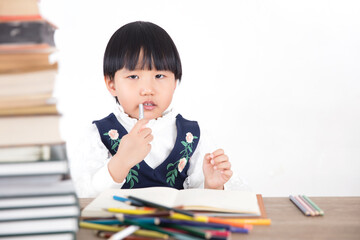 Little girl rubbing her mouth while studying