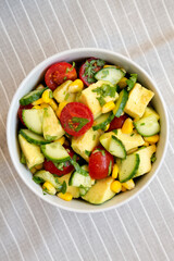 Fresh Avocado Tomato Salad in a bowl, top view. Flat lay, overhead, from above.