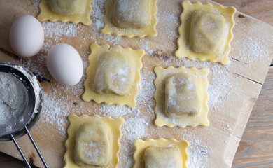 Homemade organic tortellini on a wooden plank. Top view
