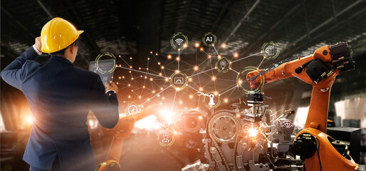 Manager engineer check and control automation robot arms machine in intelligent factory industrial on real time monitoring data software. Welding robotics and manufacturing operation.