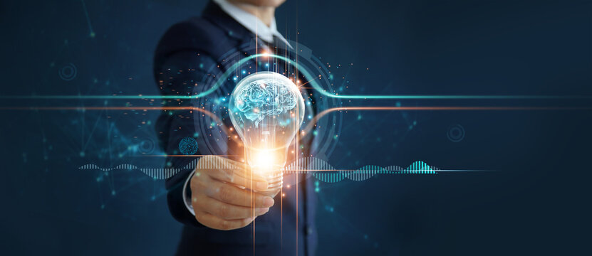 Businessman holding illuminated light bulb with brain inside, idea, creativity, innovation and inspiration of business on network connection background.