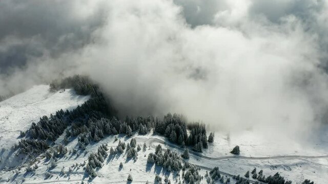 Aerial view of misty winter sunrise in the Swiss Alps mountains. Aletsch arena, Switzerland. Flying through the clouds