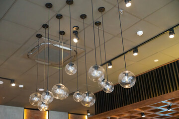 Selective focus of glass hanging lamps on white ceiling. vintage light bulbs.
