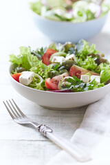Salad with Green Olives, Tomatoes and Feta Cheese. Bright wooden background.	