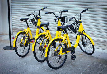 Fototapeta na wymiar Parking for three rental bicycles at street