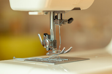 Parts and mechanisms of the sewing machine close-up. Needle and thread. Soft focus.