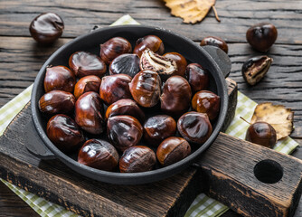 Roasted edible chestnut fruits in the pan. Top view.