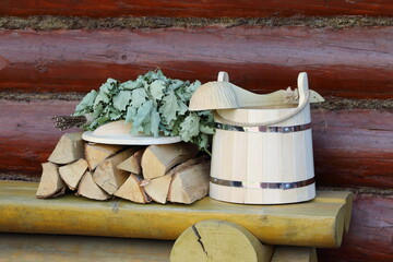 Wooden sauna accessories on yellow bench in the timber terrace. 