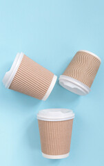 Paper cups of coffee to go on pastel background.