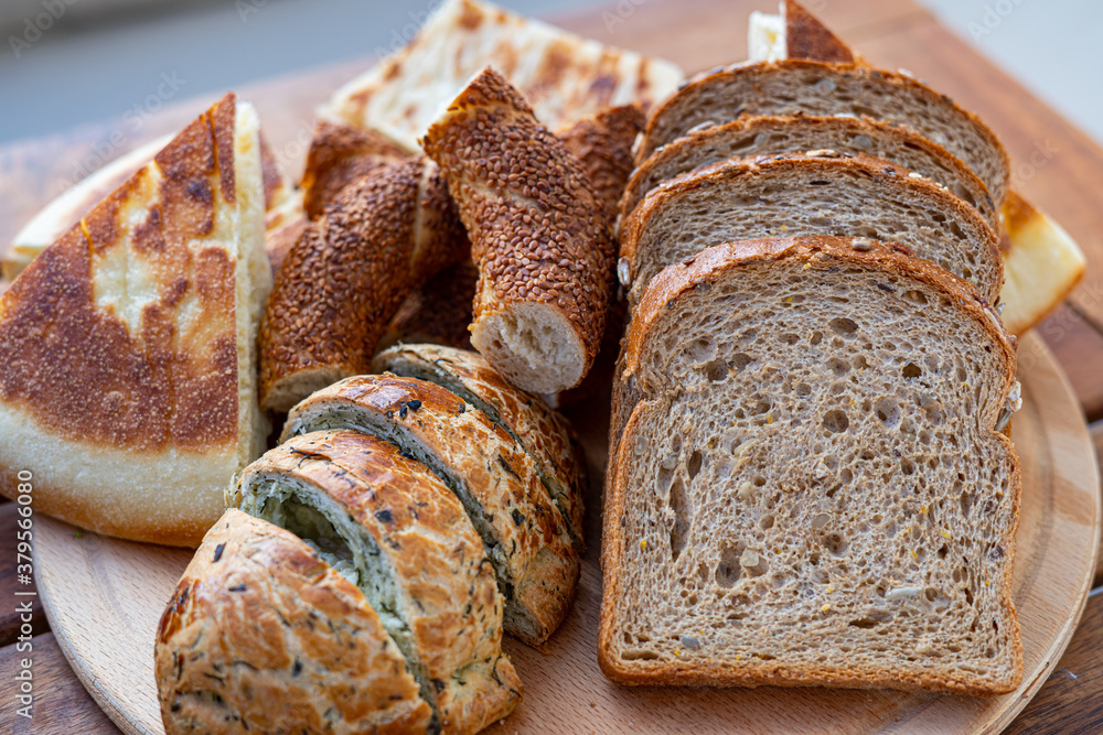 Wall mural sliced bread with different kinds of fresh baked bread as background