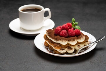 portion of Classic tiramisu dessert with raspberries and cup of coffee dark concrete background