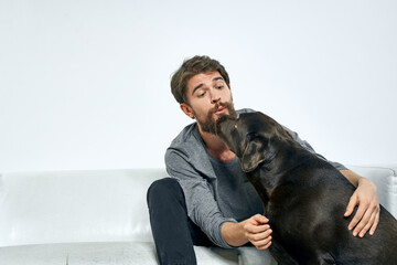 Male owner play with the dog on the couch training fun light room friends pet