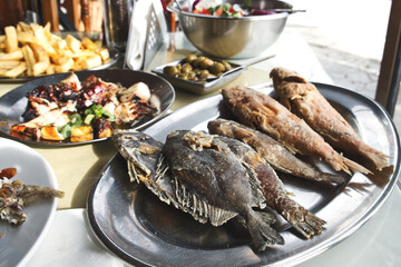 Delicious Cyprus food meze - marinated olives, grilled octopus tentacles, French fries