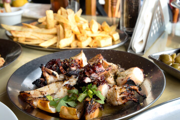 Delicious Cyprus food meze - marinated olives, grilled octopus tentacles, French fries