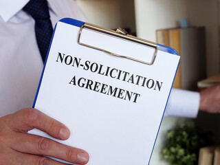 Non solicitation Agreement concept. The manager offers to sign the documents.