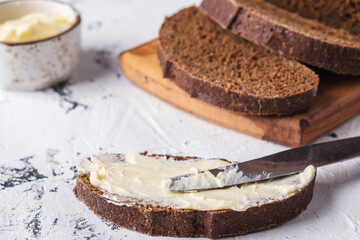 Sliced bread with butter on white background.