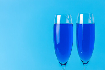 Two wineglasses close up of blue champagne on a blue background. Shallow depth of the field, copy space for you text