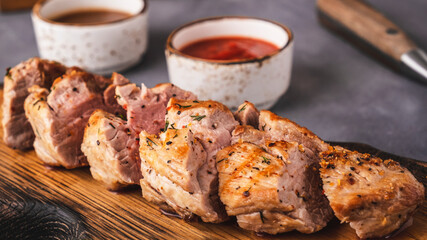 Sliced meat tenderloin on wooden cutting board. Closeup