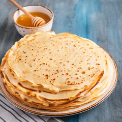 Thin pancakes on a plate with honey. Closeup.
