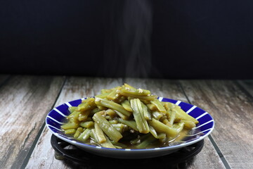 Fried and stirred cutting lotus stem with oil and seasoning with soy sauce and pepper on the plate. Famous vegetarian menu in Asia restaurant. High fiber and vitamin menu. Low fat and diet food. 
