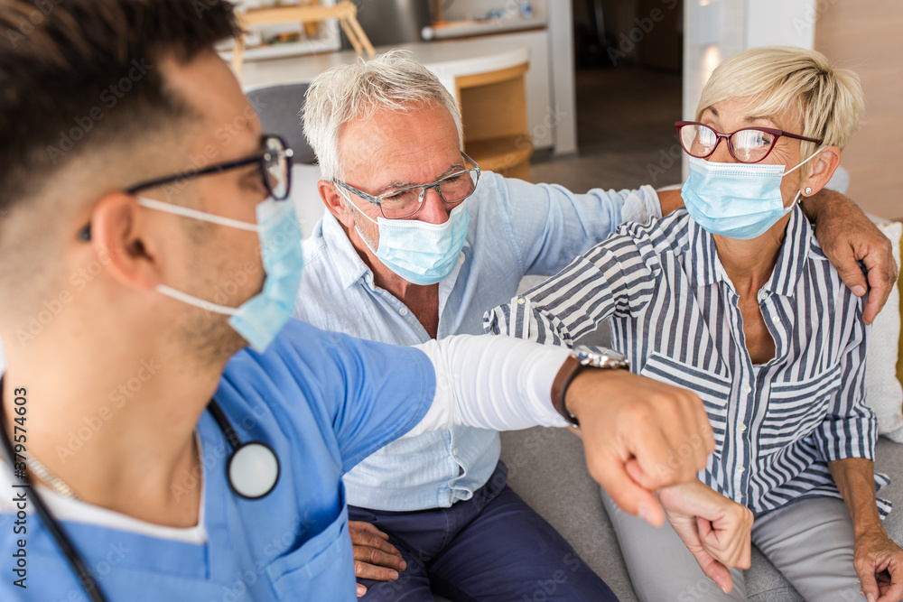 Wall mural male nurse greeting with seniors patients with mask while being in a home visit.