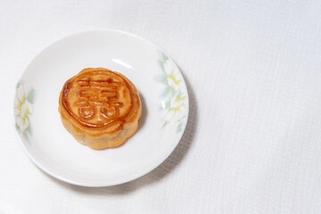 Chinese traditional food , pie with chinese character for happiness , betrothal gift , mooncake on plate