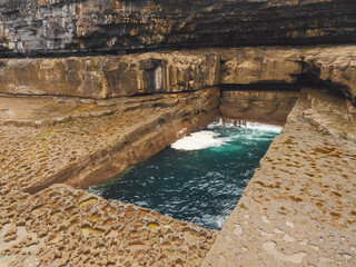 Famous and popular by tourist The Wormhole. Natural rectangular shaped pool into which the sea ebbs...