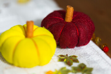 Fototapeta na wymiar Decorative colorful pumpkins made from felt, threads and cinnamon sticks 