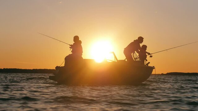 Sunset lake with a father catching fish with his sons