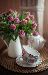 Still-life. Clover bouquet and tea service.