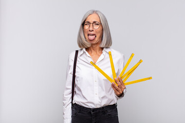 middle age woman with cheerful, carefree, rebellious attitude, joking and sticking tongue out,...