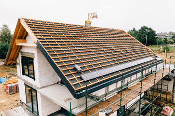 laying tiles on the roof of a single-family house - obrazy, fototapety, plakaty