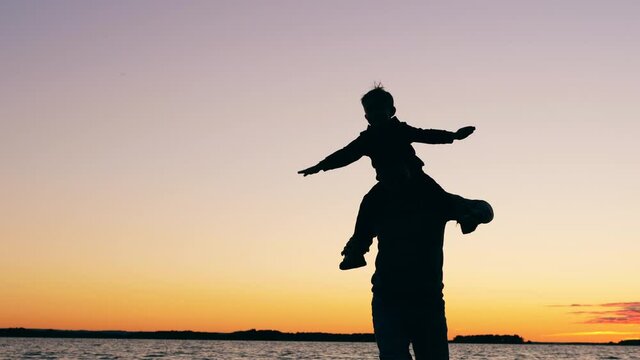 A boy and his dad are having fun at the lake