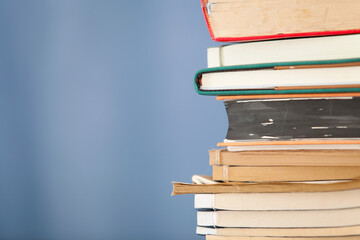 A stack of books in front of a blue background