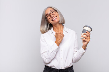 middle age woman feeling happy, positive and successful, motivated when facing a challenge or...