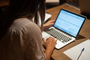 young woman with white shirt studies with computer on the table