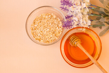 Ingredients for home Spa skin care. Glass jars with oatmeal and yellow honey. In the background is a lavender flower. The view from the top. Sunlight.
