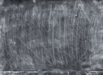 Dirty blackboard background. New academic year. White chalk strokes on weathered surface.