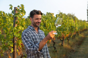 Authentic shot of happy successful male winemaker is tasting a flavor and checking wine quality...