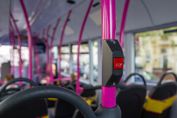 A close up of the stop button in the interior of a bus used to alert the bus driver that you would like to get off at the next bus stop