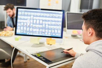 Junger Mann als Grafikdesigner am Tablet Computer