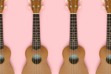 Small guitars on a pink pastel background. Musical equipment flat lay composition.