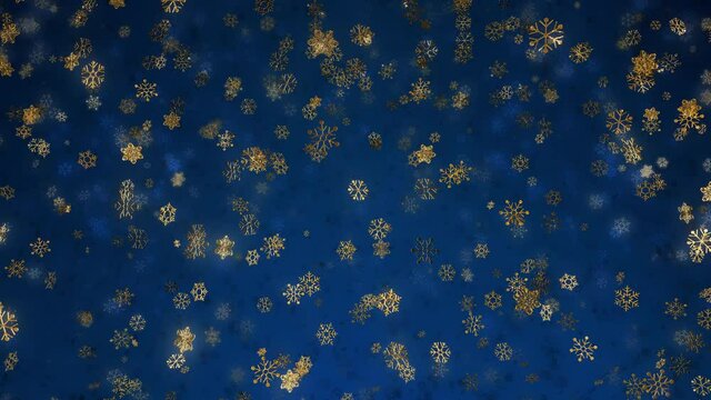 Golden snowflakes sparkle glitter background loop with bokeh effect and selective focus. Festive Christmas and New Year's Eve wallpaper concept as a bright gold on blue full-frame abstract backplate.