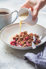 Vegan breakfast - baked oatmeal with berries and oat milk in white bowl.