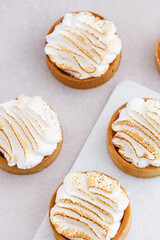 Tartlets with whipped cream close up on white marble kitchen table