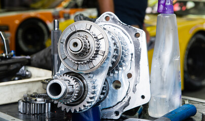 Close up of gear wheel of motor sport car on mechanics table in circuit paddock box