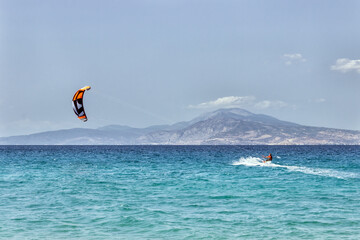  Kitesurfing on the sea. Colorful kites fly in the blue sky.