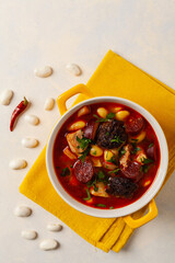 Traditional Spanish goulash soup. Fabada Asturiana. Served with a yellow clay pot with lid. Top...