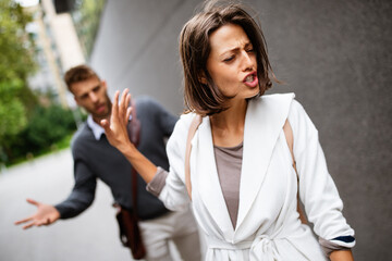 Fototapeta premium Sad young woman and man outdoor on street having relationship problems